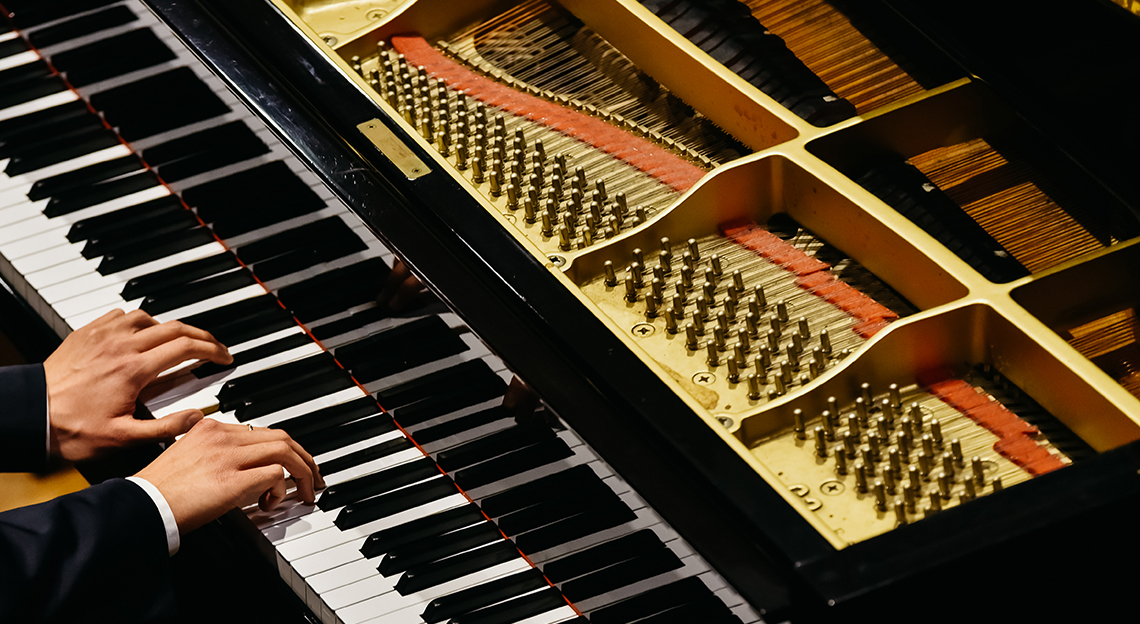 A grand piano being recorded with DPA microphones in a studio.